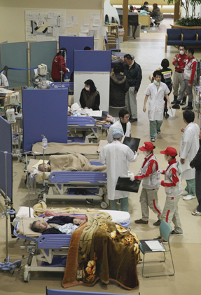 Emergency doctors and nurses treat earthquake victims at the lobby of the Ishinomaki Red Cross Hospital in Ishinomaki northeastern Japan two weeks after the earthquake and tsunami devastated northea