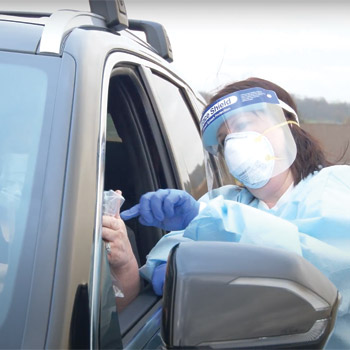 Jennifer Holbein certified medical assistant dons full personal protective equipment during a drive-in visit Image by Elliott Cramer